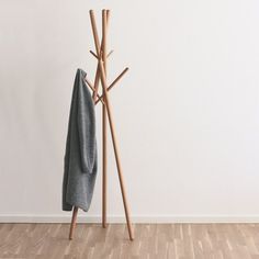 a coat rack with two coats hanging from it's sides and a towel on the other side