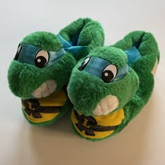 a pair of green and yellow slippers sitting on top of a white countertop