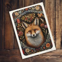 a card with an image of a fox on it's face and flowers in the background