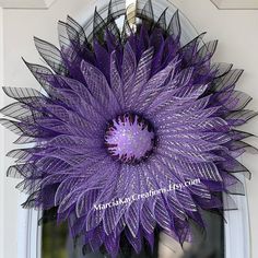 a purple flower hanging from the side of a door