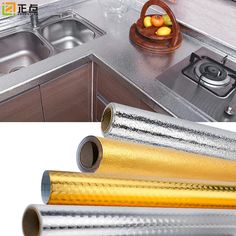 the kitchen counter is covered in metallic foil and there are two rolls of tape next to the sink