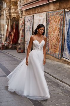 a woman in a wedding dress walking down the street