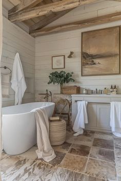 a white bath tub sitting next to a sink under a wooden beam in a bathroom