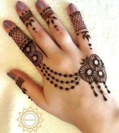 a woman's hand with henna tattoos on it