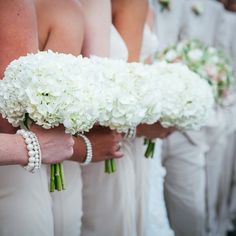 bridesmaids in white dresses holding bouquets of flowers