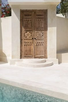 an old door is open in front of a pool