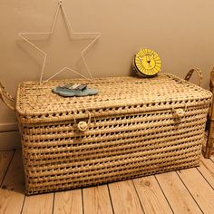 a wicker trunk with a yellow clock on top and a star decoration above it