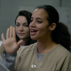 two women in scrubs are smiling and waving