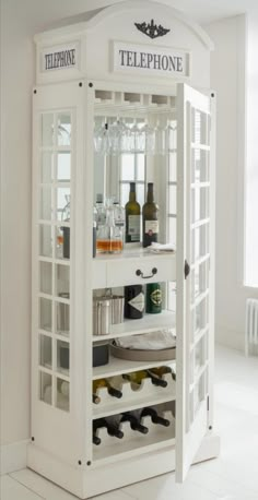 a white phone booth with bottles and glasses in it