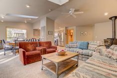 a living room with couches, chairs and a table in it's center