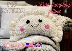 a knitted sheep pillow sitting on top of a bed