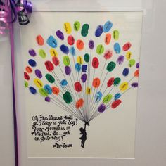 an art piece with words written on it and a purple ribbon hanging from the wall