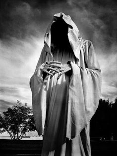 a black and white photo of a person dressed in a ghost costume with hands on their hips