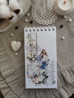 a spiral notebook sitting on top of a table next to cotton balls and other items