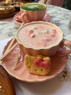 a pink plate topped with a cup of hot chocolate