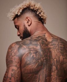 the back of a man with tattoos on his body