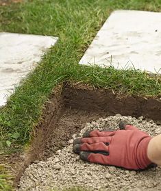 a person laying on top of a pile of dirt next to a white triangle shaped object