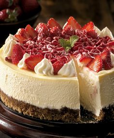 a cheesecake topped with strawberries on top of a wooden table