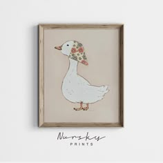 a white duck with a flowered hat on it's head is framed in a wood frame