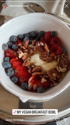 a bowl filled with fruit and yogurt sitting on top of a silver tray