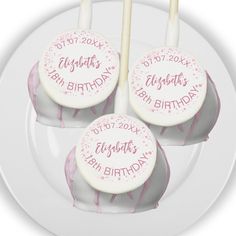 three birthday cake pops on a white plate