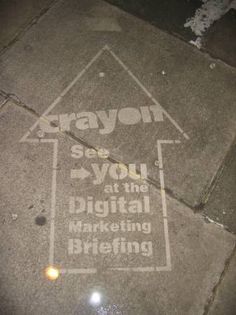 a street sign on the sidewalk that says crayon you at the digital marketing briefing