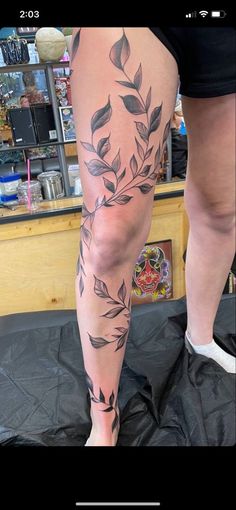 a woman's legs with leaves on them and the bottom part of her leg