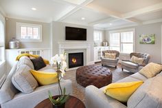 a living room filled with furniture and a flat screen tv mounted on the wall above a fire place