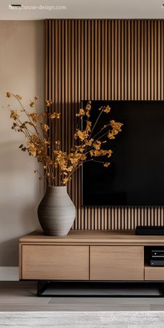 a vase filled with flowers sitting on top of a tv stand