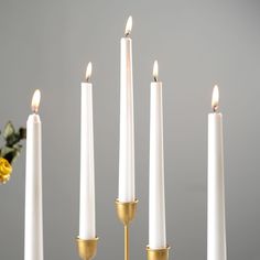 five white candles are lined up next to each other with one candle in the middle