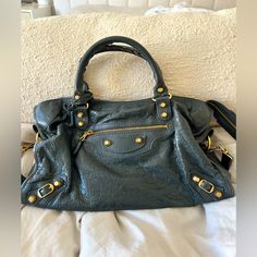 Agneau Giant 12 Gold Hardware In Mini City Anthracite Color. Super Cute Color And In Excellent Condition. Base Length: 9.25 In Height: 6.00 In Width: 3.25 In Drop: 3.25 In Drop: 18.25 In This Chic Tote Is Crafted Of Agneau Leather In Grey. The Shoulder Bag Features An Exterior Zipper Pocket, A Companion Mirror, Rolled Leather Top Handles With Handwoven Whipstitch Detail, And Polished Gold Buckles With Decorative Studs. The Top Zipper Opens To A Black Fabric Interior With A Zipper Pocket. Bags Balenciaga, Gold City, Mini City, City Bag, Leather Top, Christmas List, Black Fabric, Gold Hardware, Zipper Pocket