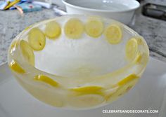 a glass bowl filled with lemon slices on top of a white plate