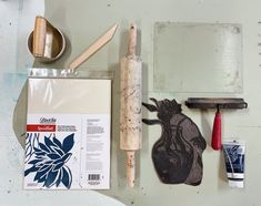 some tools are laying out on the table next to each other, including paintbrushes and glue