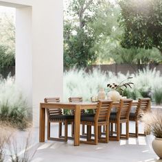 an outdoor dining table and chairs with vases on it