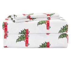 two sheets with christmas trees on them and red bows around the edges are folded in front of each other