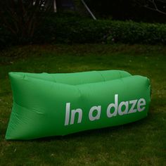 an inflatable pillow sitting on top of a lush green field