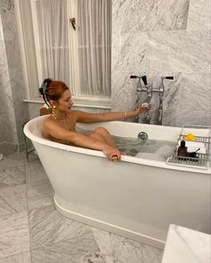 a woman sitting in a bathtub with her legs crossed