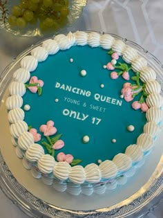 a cake that is sitting on top of a glass platter, with the words'dancing queen young & sweet only 17'written on it