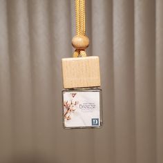 a small wooden block hanging from a string with a bead around it's end