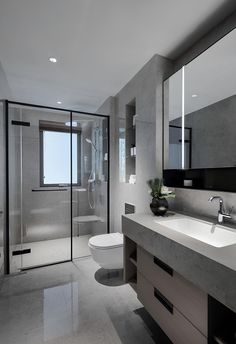 a bathroom with a sink, toilet and shower stall in the middle of the room