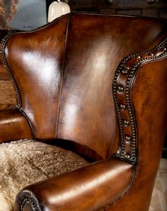 a brown leather chair sitting on top of a white rug