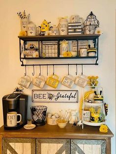 a coffee bar with mugs, plates and cups on the shelves above it is decorated with yellow flowers