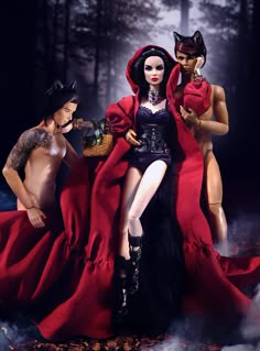 two dolls dressed in red and black standing next to each other