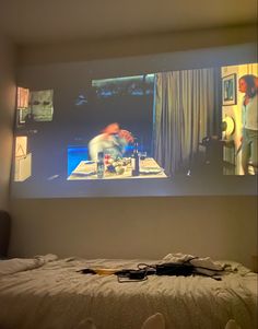 an image of a person watching something on the screen in front of them while sitting at a bed