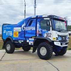 a blue and white truck parked in a parking lot