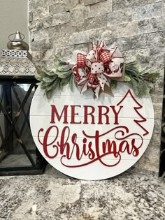 a merry christmas sign on the side of a building with wreaths and lights around it