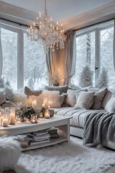 a living room filled with lots of white furniture and candles on top of the coffee table