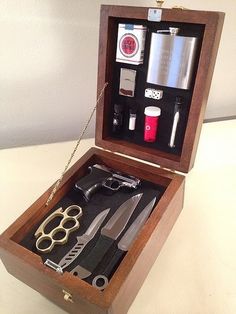 an open wooden box with scissors, flasks and other items inside on a table