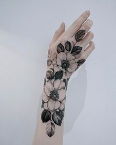 a woman's arm with black and white flowers on it