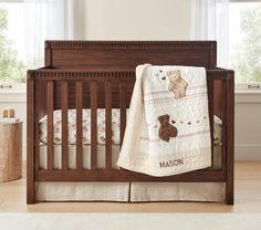 a baby crib with a teddy bear blanket on it